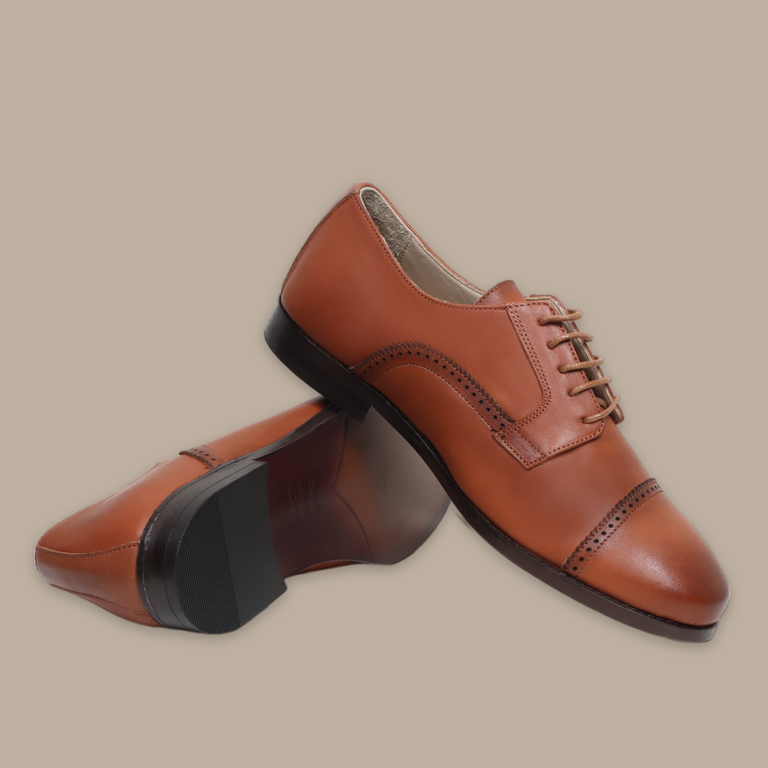 Brown leather Oxford shoes with cap toe and brogue detailing, black sole and heel.