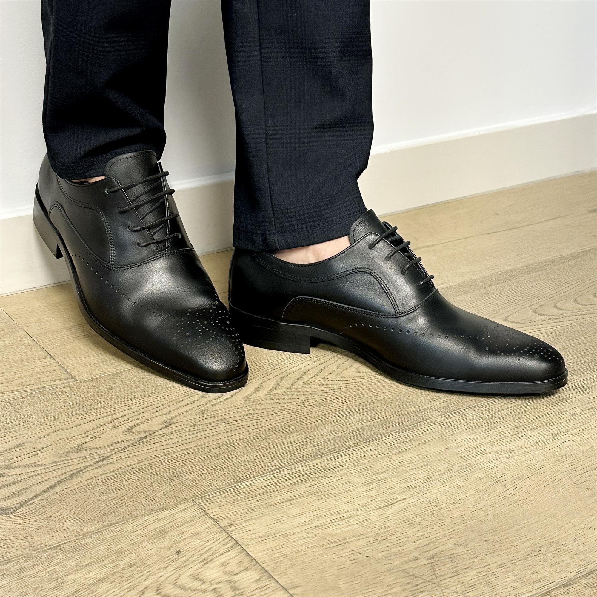 Black leather classic English lace-up shoes with pointed toes and minimal stitching detail.